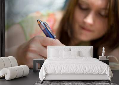 Girl writing in exercise book Wall mural