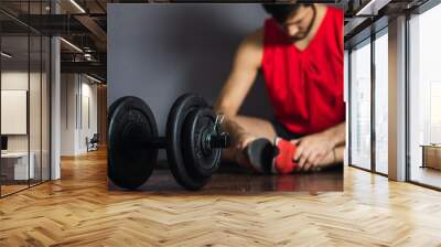 young man stretching after training with dumbbells Wall mural