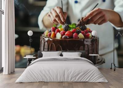 In the kitchen, a pastry chef is creating a cake with chocolate, fruit, and candy.Chocolate cake decoration, cooking classes, baking, and the concepts of food and people are all done by confectioners. Wall mural