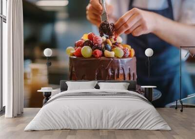 In the kitchen, a pastry chef is creating a cake with chocolate, fruit, and candy.Chocolate cake decoration, cooking classes, baking, and the concepts of food and people are all done by confectioners. Wall mural