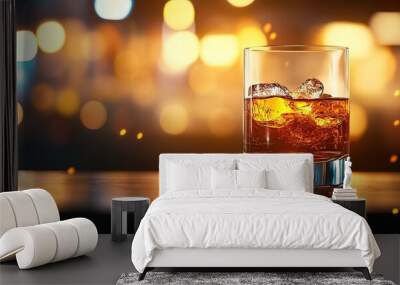 A close-up of a whiskey glass with ice, glowing against a soft bokeh background, ideal for bar, drink, or celebration themes. Wall mural