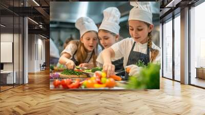 Group of children wearing chef hats and aprons, chopping vegetables and preparing food together in a professional kitchen setting. Wall mural