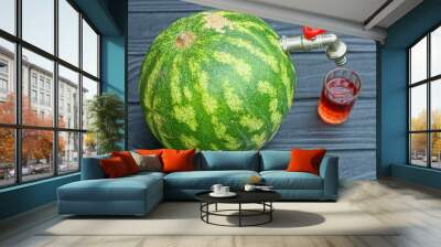 one new modern red handle contemporary industrial water small water tap iron faucet sticking out in green fresh tasty whole round watermelon with glass cup with cherry juice on black wooden table Wall mural