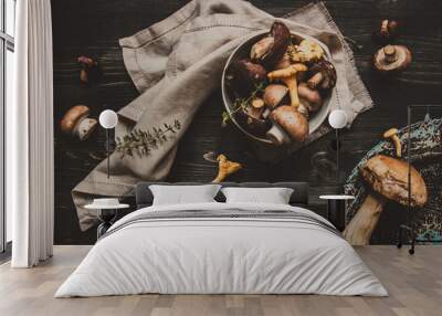 Fresh mixed forest mushrooms on the wooden black table Wall mural