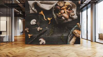 Fresh mixed forest mushrooms on the wooden black table Wall mural