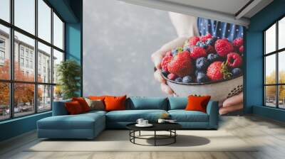 Hands holding fresh juicy berries. Summer background with copy space Wall mural