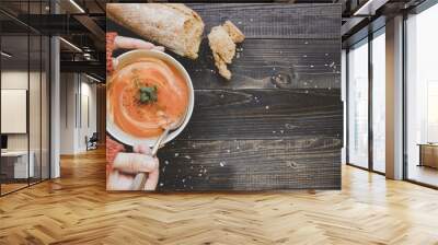 Hands holding hot cream soup on the wooden table, top view. With copy space Wall mural