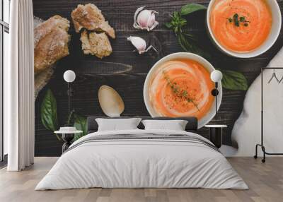 Tomato cream soup with bread on the wooden table, top view Wall mural