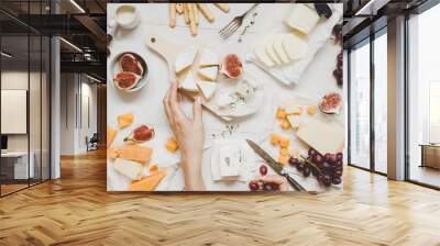 Various types of cheese with fruits and snacks on the wooden white table. Top view Wall mural