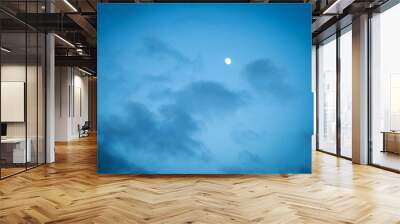 The moon on a cloudy evening sky Wall mural