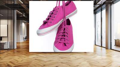 Magenta sneakers hang on laces isolated on a white Wall mural