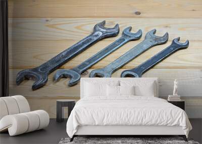 Old used wrenches on a wooden background. Vintage spanners Wall mural