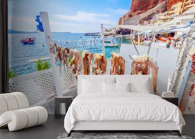 Dry octopus on the rope on Santorini island in Aegean sea of Greece. Restaurant background. Wall mural