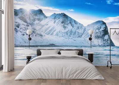 Iconic arctic surf beach - UNSTAD, located over polar circle in Norway, Moskenes on Lofoten islands. Man surfer going with surf board into Norwegian sea waters at epic rocks background. Winter season. Wall mural