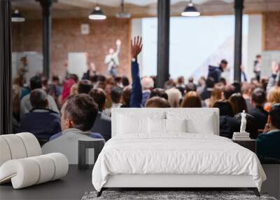 Large group of people at the Conference Watching Presentation and listening to speaker. Business people concept and Ideas, education. Speaker interacting to listener from auditorium, raising hang. Wall mural