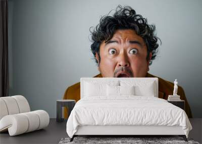 a young asian fat man in casual dress looking camera with excited look and humorous distortions on white background Wall mural