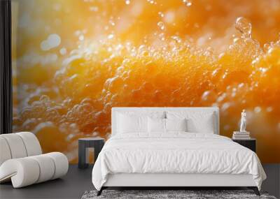 Close-up view of frothy orange liquid with bubbles, creating a vibrant and dynamic abstract background. Wall mural