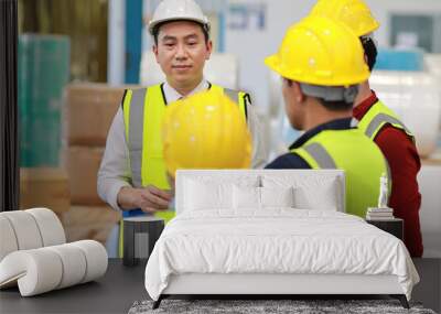 Group of asian technician engineer and businessman in protective uniform standing and discussing, researching, brainstorming and planning work together with hardhat at industry manufacturing factory Wall mural