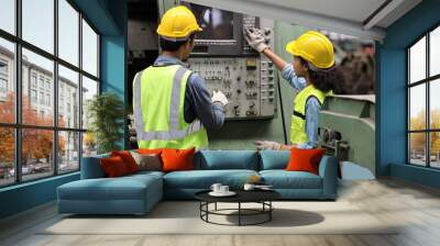 Group of technician engineer or worker in protective uniform standing and using tablet while controlling operation or checking industry machine process at heavy industry manufacturing factory Wall mural