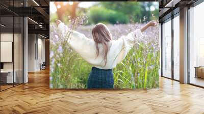 portrait of beautiful woman having a happy time and enjoying among flower naga-crested field in natu Wall mural