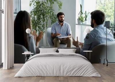 A man is talking to two people during a meeting.  Wall mural