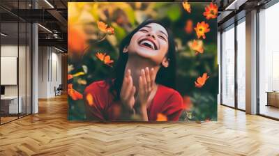 A young woman in a red shirt laughs in a field of flowers. Wall mural