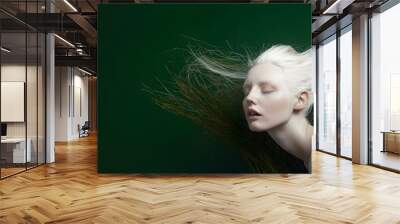 A young woman with long, flowing white hair looks up with her eyes closed. Wall mural