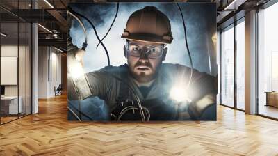 Electrician working in a dark and smoky environment, using flashlights to illuminate his work. Wall mural