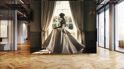 Elegant bride in white gown standing gracefully by a sunlit window, exuding timeless beauty Wall mural