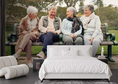 Conversation, nature and mature friends in a park sitting on bench for fresh air together. Happy, smile and group of senior people in retirement in discussion or talking in an outdoor green garden. Wall mural