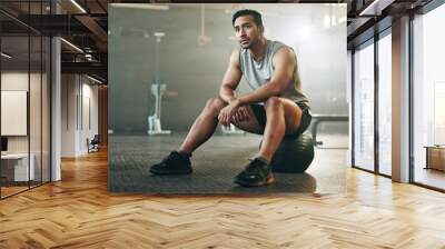 Fitness, breathing and sweating with a tired man in the gym, resting after an intense workout. Exercise, health and fatigue with a young athlete in recovery from training for sports or wellness Wall mural