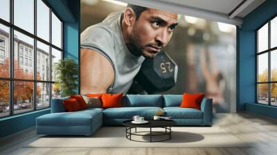 Serious man, dumbbell and weightlifting in workout, exercise or fitness at indoor gym. Active male person, bodybuilder or athlete lifting weight for intense arm training, strength or muscle at club Wall mural