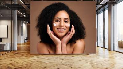 Skincare, sunscreen and black woman in portrait for facial, beauty and cosmetics promotion of product in studio. Happy African model with skin care, dermatology and cream, hands and face for wellness Wall mural