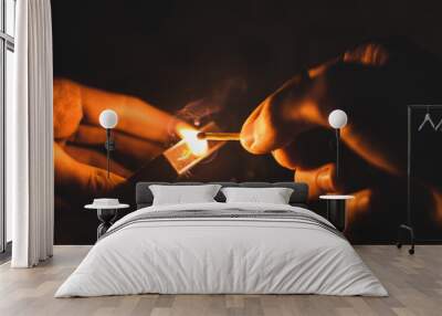 Magic lit match with cool colored smoke in the hands, warm color Wall mural