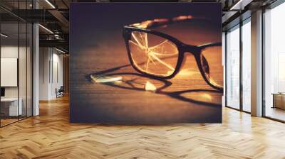 dramatic lit image of broken glasses on the floor / selective focus on the right eye Wall mural