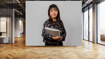 Hispanic woman with notebook and pencil - Young female entrepreneur smiling - Latina college student on white background Wall mural