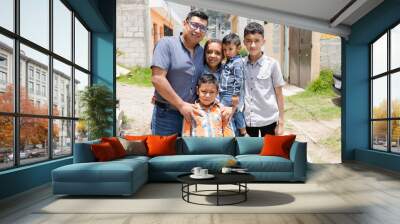 Latin family hugging outside their house in rural area - Happy Hispanic family in the village Wall mural