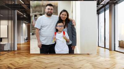 Portrait of Hispanic family - Latino parents with their son who goes to school with his backpack - parents proud of their son who is going to study Wall mural