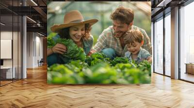 Joyful farmer family picking fresh lettuce and vegetables from the greenhouse. A glimpse into a wholesome lifestyle. Wall mural