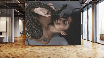 Sensual tattooed woman with big snake and iron corset Wall mural