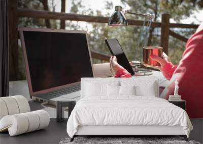 woman with phone in hand, outdoor influencer work table with computer, and office supplies, Wall mural