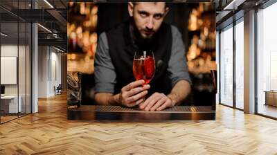 Bartender serving a delicious cocktail with a decor of red slice Wall mural