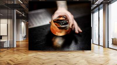 Bartender serving James Cook cocktail in the glass with orange zest Wall mural