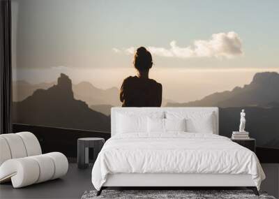 Girl in stylish clothes stands in mountains Wall mural