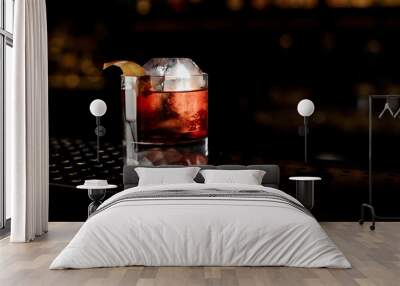 Glass of a Boulevardier cocktail with orange zest on the steel bar counter Wall mural