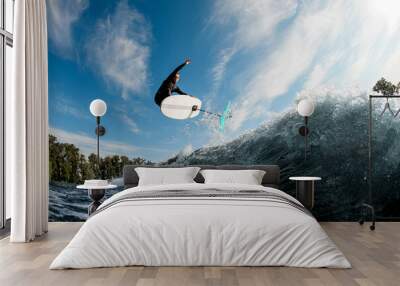 Great view of active man skillfully jumping on the wave with hydrofoil foilboard Wall mural