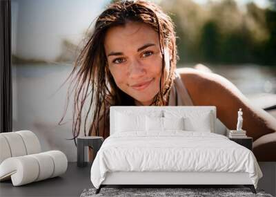 Portrait of beautiful woman with brown wet hair on blurred background beach Wall mural