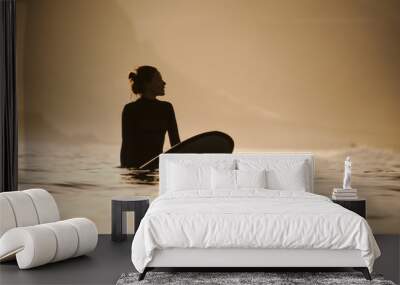 Silhouette of a surfer girl in the waters Wall mural