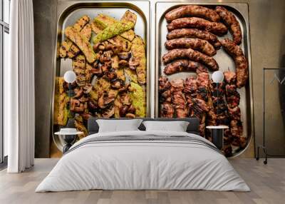 Top view of two metal trays with grilled meat, sausages, vegetables and mushrooms Wall mural