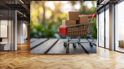 Mini shopping cart filled with cardboard boxes on a wooden table. Wall mural